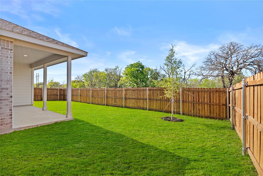 904 Traction Trail Cleburne, TX 76031 - Photo 25 of 27 a view of a backyard with a garden and entertaining space