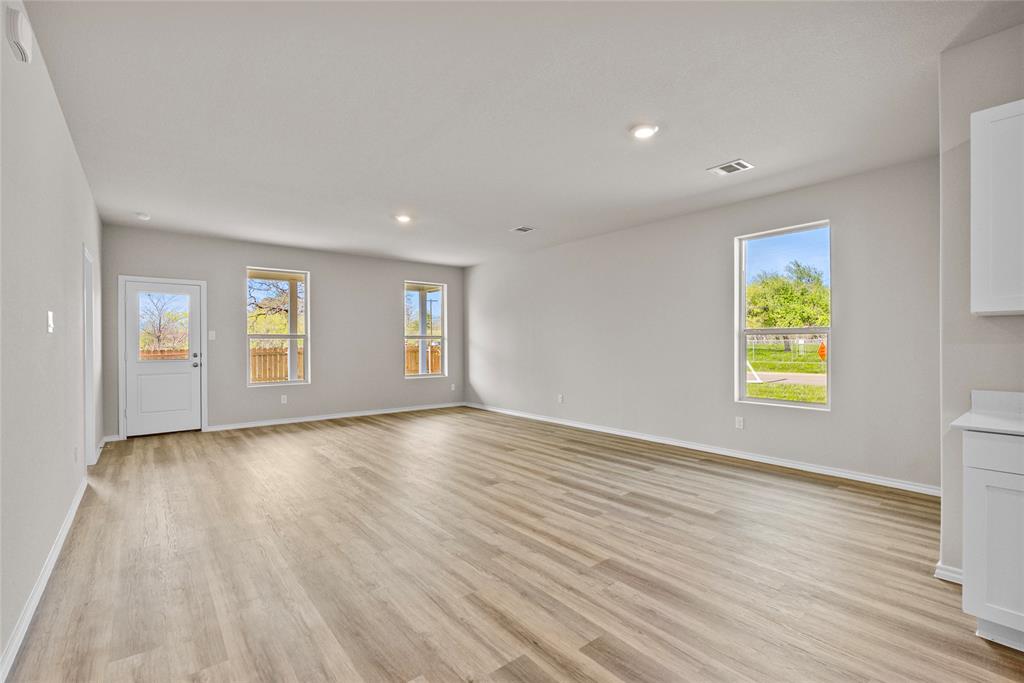 904 Traction Trail Cleburne, TX 76031 - Photo 5 of 27 an empty room with window and wooden floor
