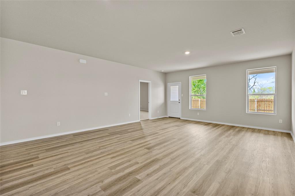 904 Traction Trail Cleburne, TX 76031 - Photo 6 of 27 an empty room with wooden floor and windows