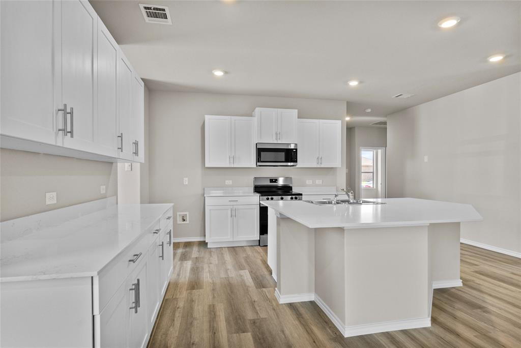 904 Traction Trail Cleburne, TX 76031 - Photo 9 of 27 a kitchen with white cabinets appliances and sink