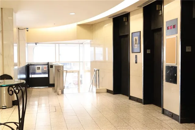 a view of a hallway with furniture and a window