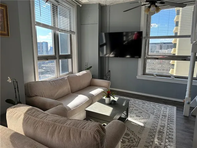 a living room with furniture a flat screen tv and a window