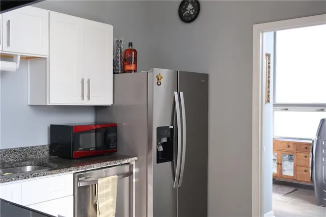 a kitchen with stainless steel appliances granite countertop a refrigerator and a sink