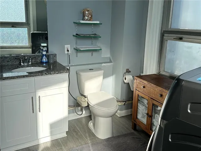 a bathroom with a granite countertop toilet sink and mirror