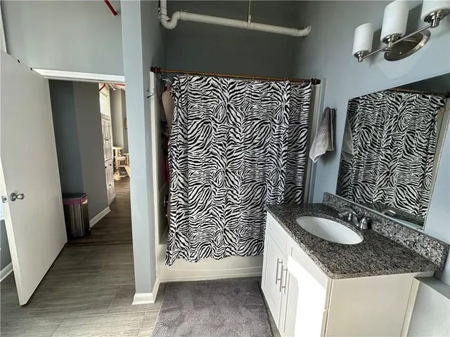 a bathroom with a granite countertop sink and a mirror
