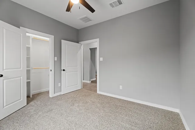 an empty room with chandelier fan