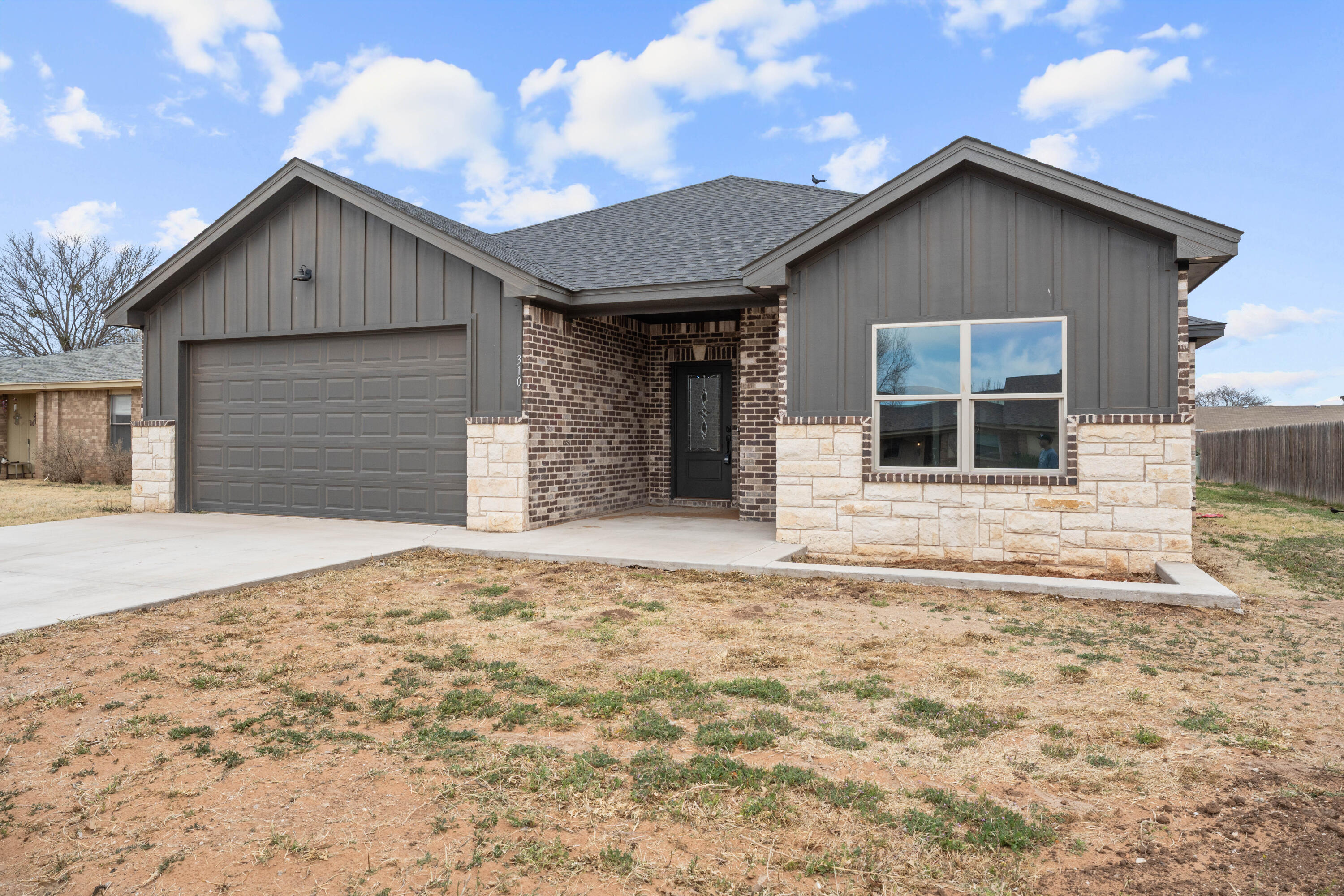 310 East 16th Street Wolfforth, TX 79382 - Photo 3 of 30 a front view of a house with a yard and garage