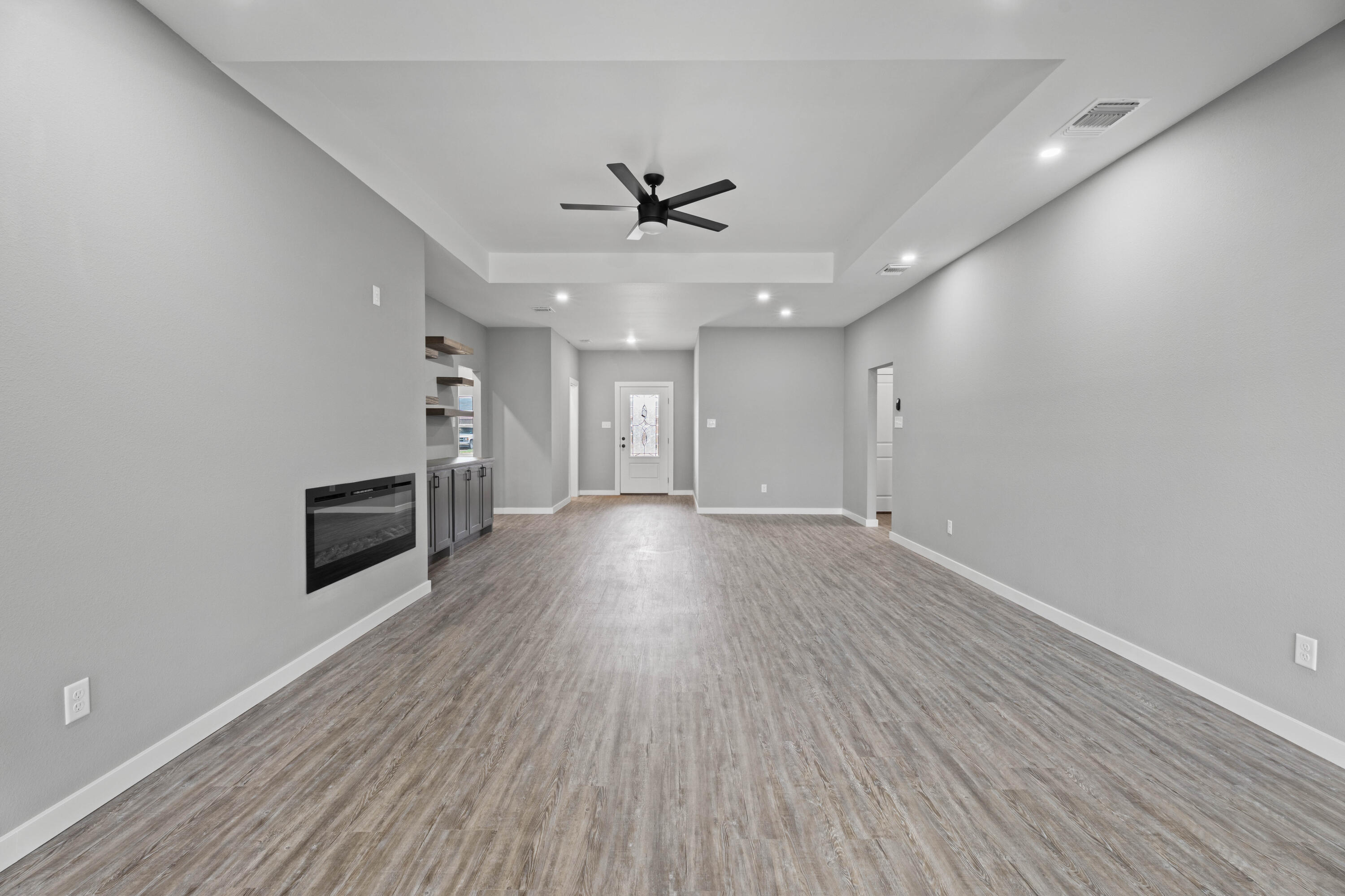 310 East 16th Street Wolfforth, TX 79382 - Photo 6 of 30 an empty room with wooden floor ceiling fan and windows