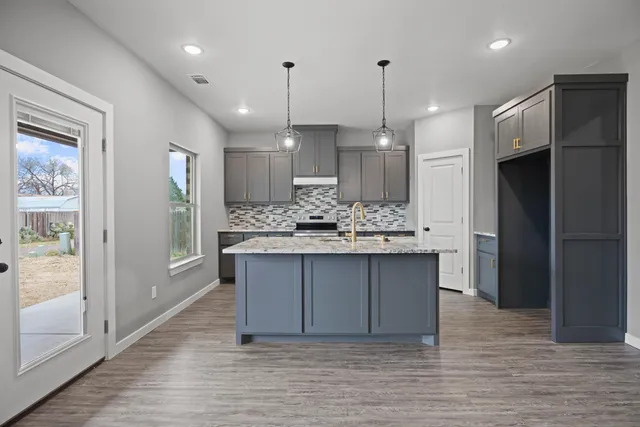 a view of kitchen with kitchen island white cabinetry and refrigerator