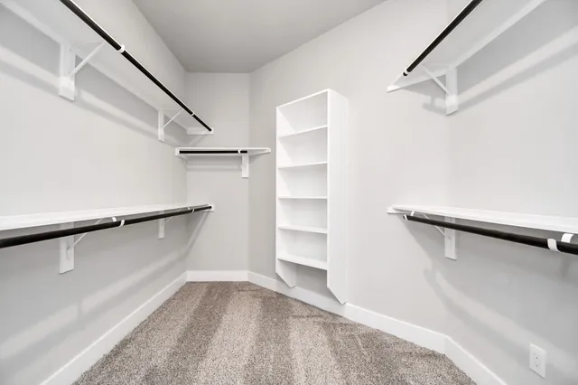 a view of walk in closet with empty racks
