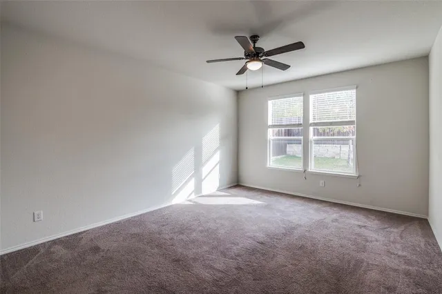 a view of a livingroom with a ceiling fan and window