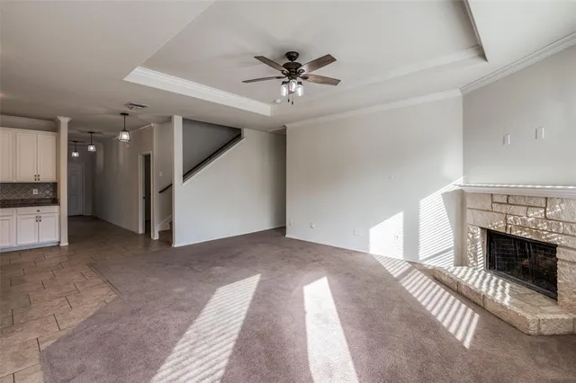 a view of a livingroom with a ceiling fan a fireplace and entryway