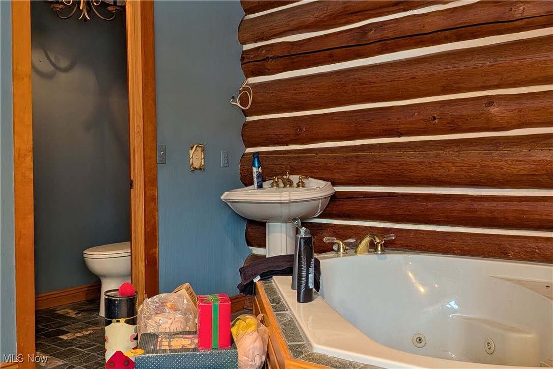 8026 Lee Road Northwest Malvern, OH 44644 - Photo 19 of 44 Bathroom featuring a jetted tub and a chandelier