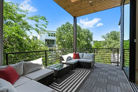 a balcony with wooden floor and outdoor seating