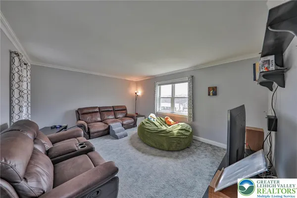 a living room with furniture a window and a flat screen tv