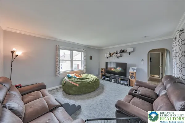 a living room with furniture a flat screen tv and a window