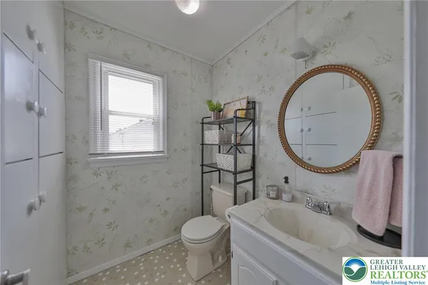 a bathroom with a sink a toilet and a mirror