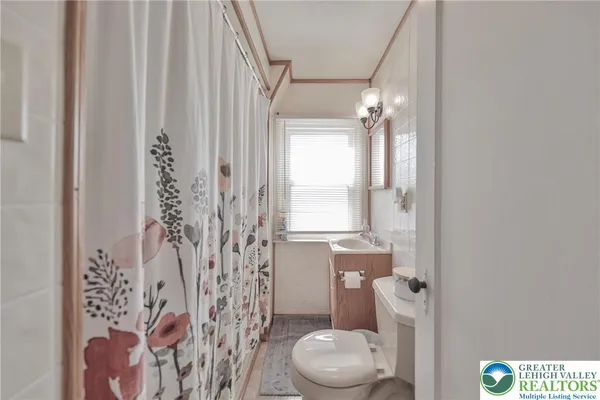a white toilet sitting next to a shower curtain