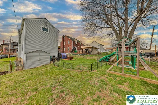 a view of a house with a yard and a slide