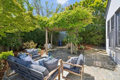 a view of a deck with table and chairs potted plants with wooden fence