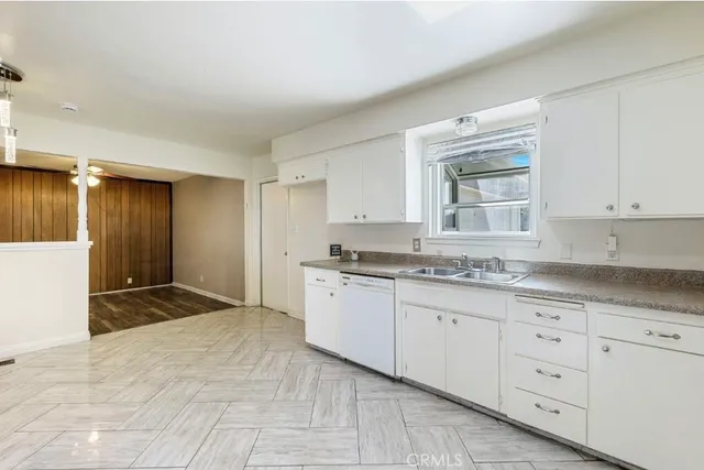 a kitchen with granite countertop a sink and cabinets