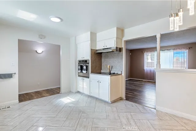 a view of kitchen with stainless steel appliances cabinets and window