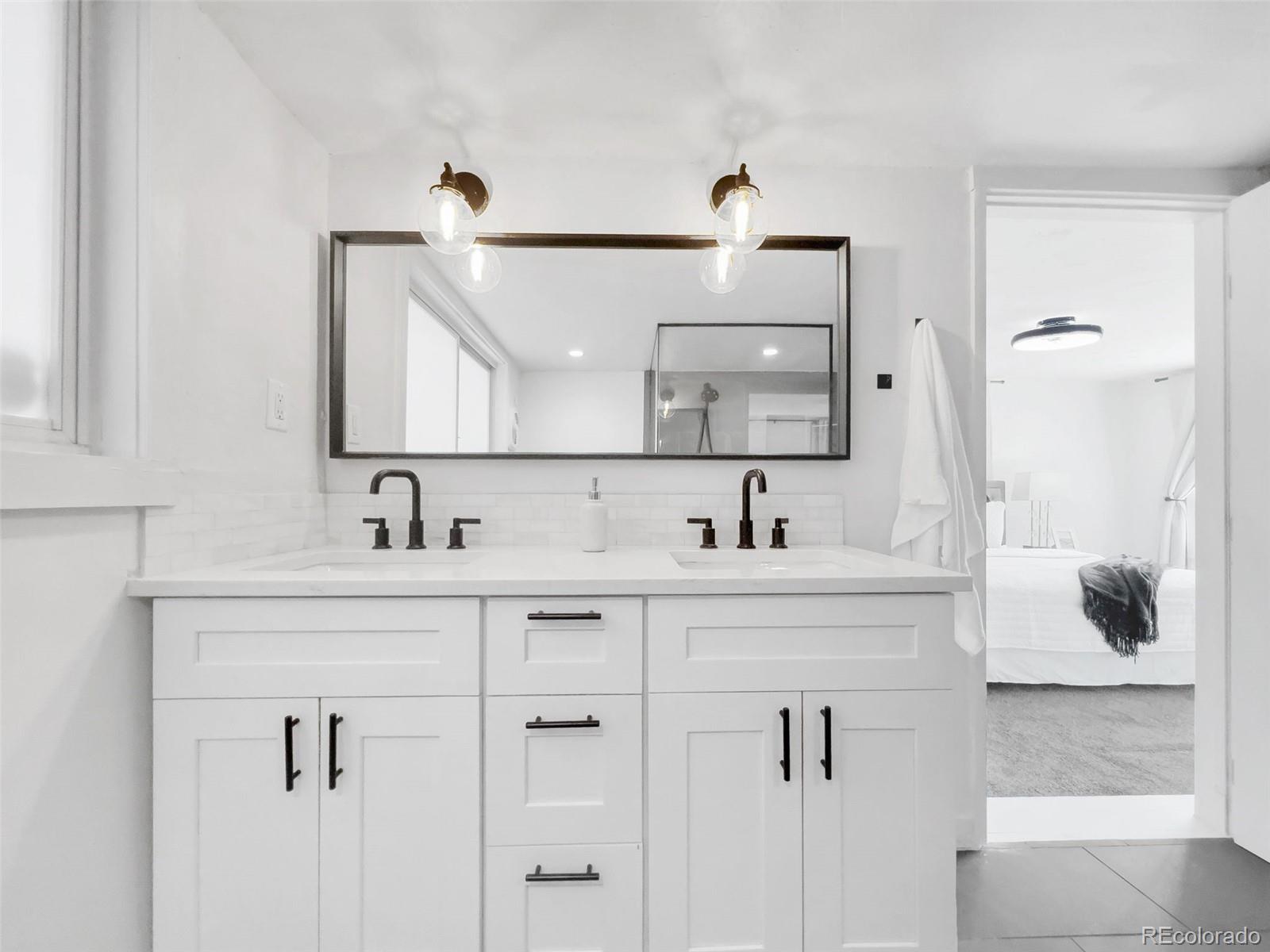 2900 Benton Street Wheat Ridge, CO 80214 - Photo 22 of 43 a bathroom with double vanity sink a mirror and shower
