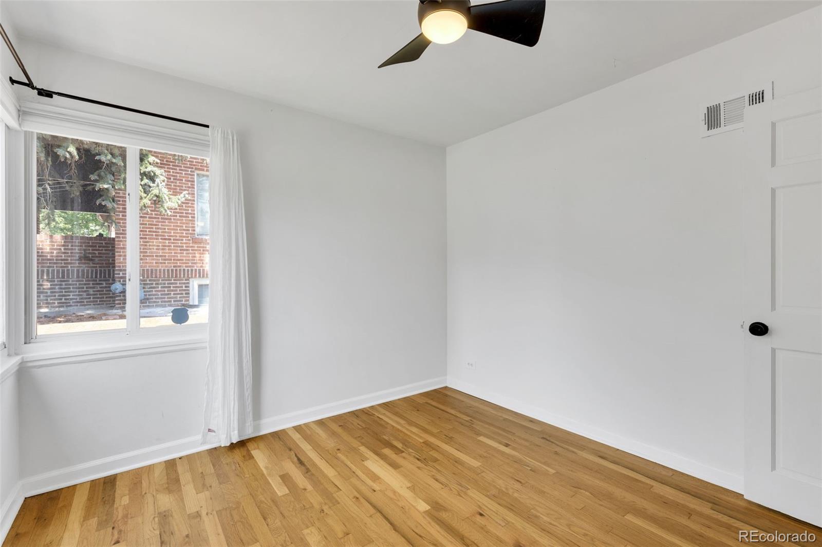 2900 Benton Street Wheat Ridge, CO 80214 - Photo 26 of 43 a view of empty room with wooden floor and fan
