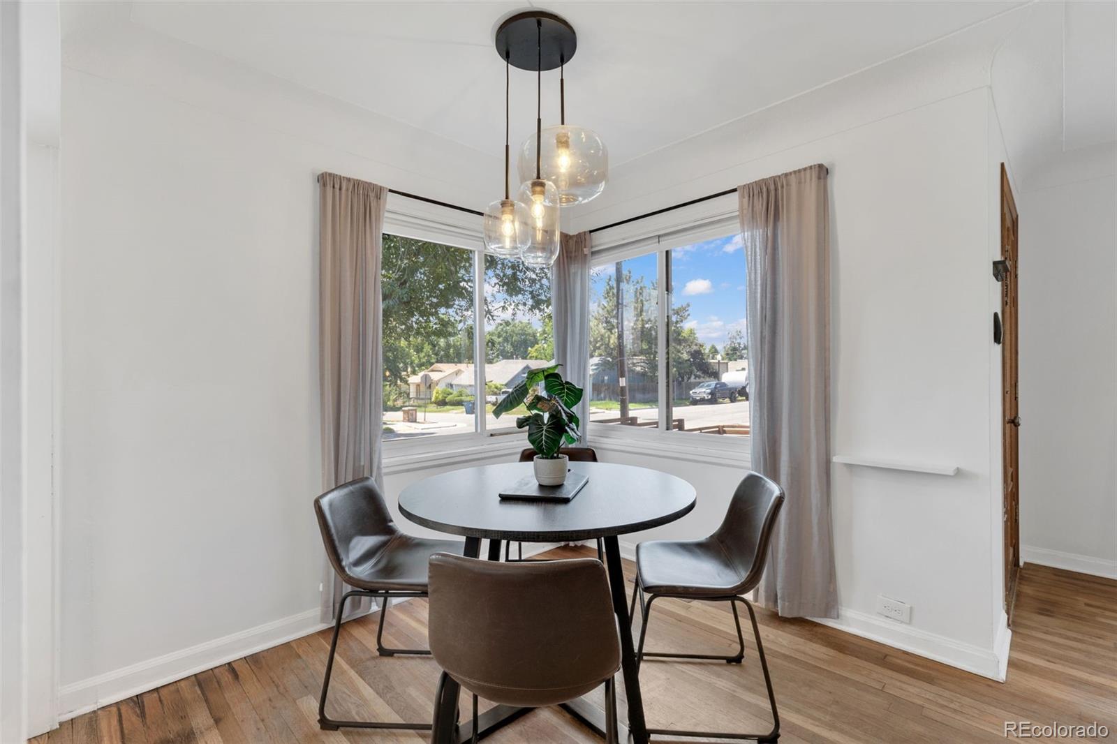 2900 Benton Street Wheat Ridge, CO 80214 - Photo 8 of 43 a dining room with furniture a chandelier and wooden floor