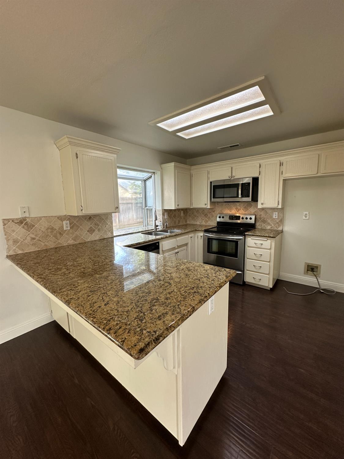 1816 East Frederick Avenue Fresno, CA 93720 - Photo 14 of 29 a kitchen with kitchen island a sink stove and wooden floor