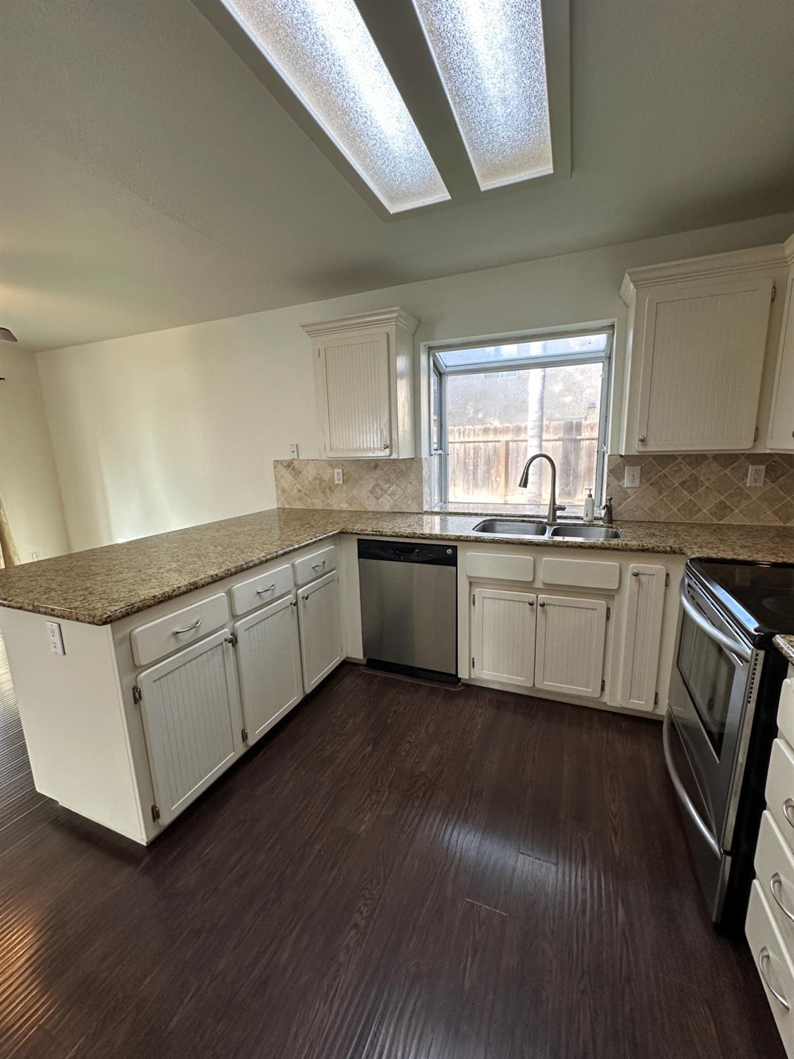 1816 East Frederick Avenue Fresno, CA 93720 - Photo 15 of 29 a kitchen with stainless steel appliances granite countertop a sink cabinets and wooden floor