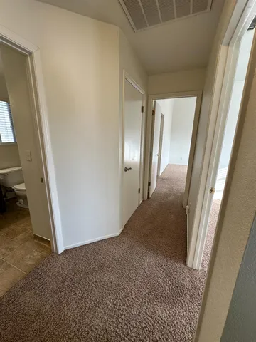 an empty room with windows and ceiling fan