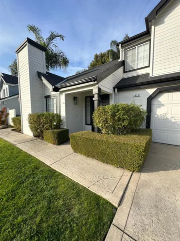 a front view of a house with a yard and potted plants
