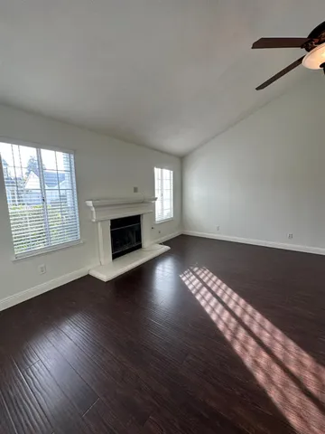 a view of wooden floor fire place and windows in a room