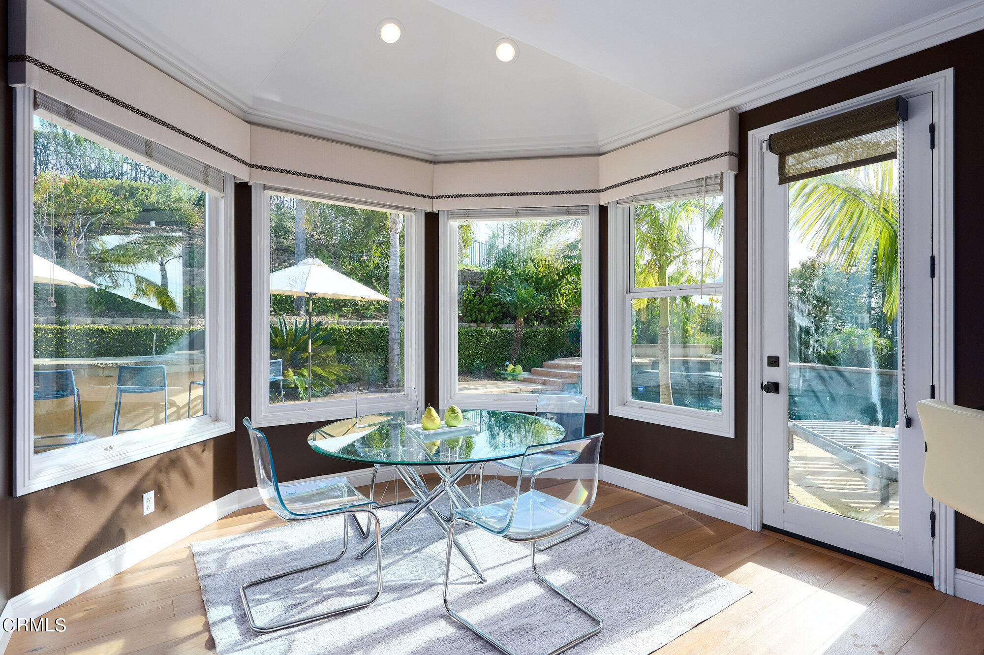 7159 Los Coyotes Place Camarillo, CA 93012 - Photo 20 of 73 a dining room with wooden floor and a dining table with garden view