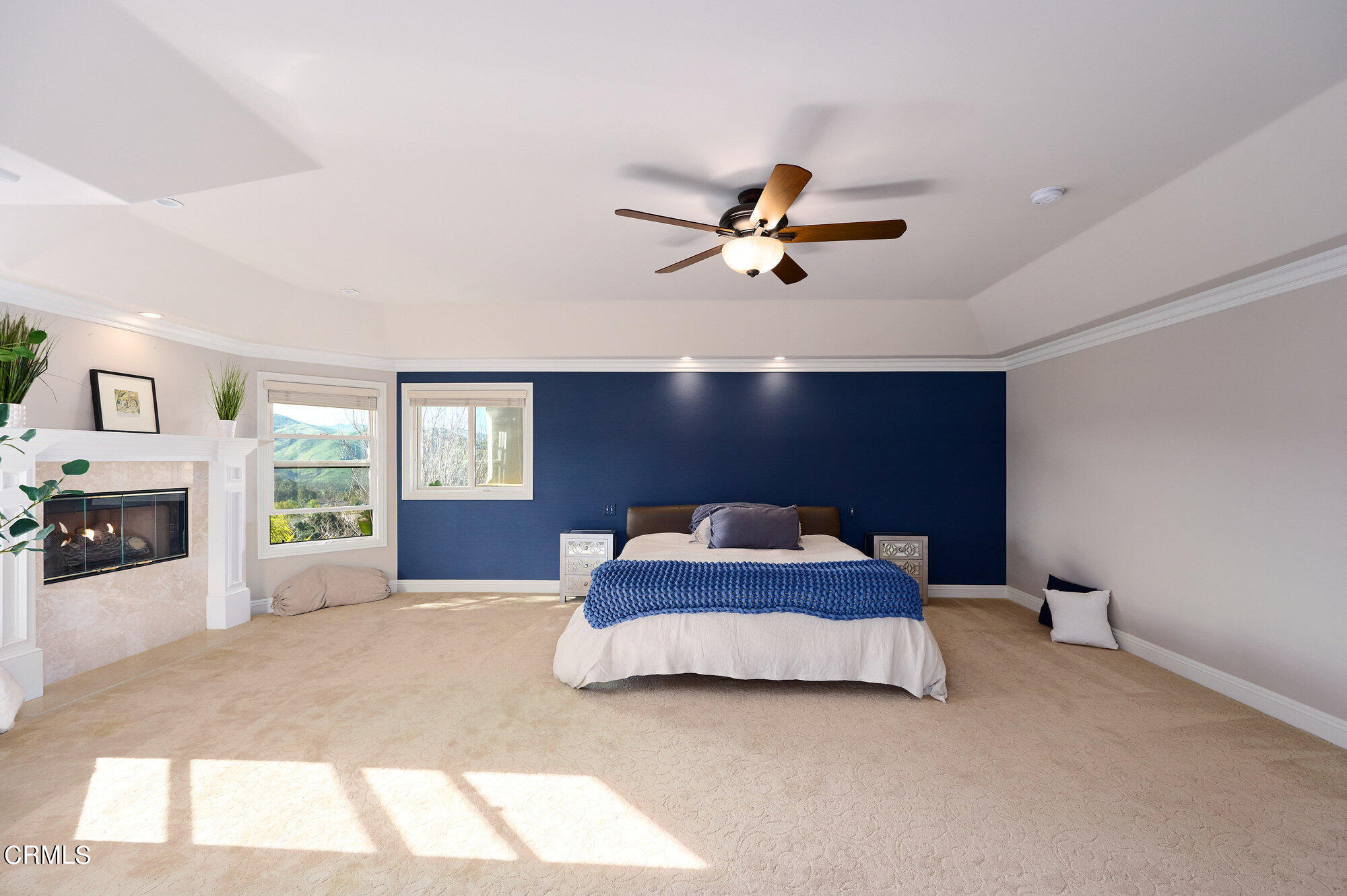 7159 Los Coyotes Place Camarillo, CA 93012 - Photo 36 of 73 a spacious bedroom with a large bed chandelier and fireplace