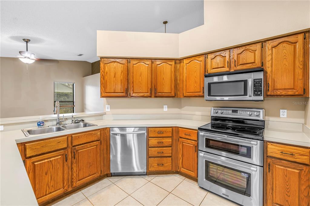 8436 Ridgebrook Circle Odessa, FL 33556 - Photo 7 of 58 a kitchen with stainless steel appliances granite countertop a stove sink microwave and cabinets