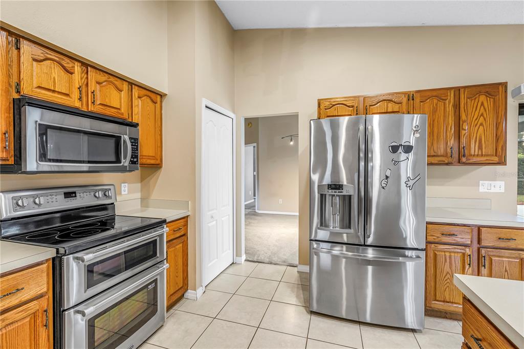 8436 Ridgebrook Circle Odessa, FL 33556 - Photo 8 of 58 a kitchen with a refrigerator and a stove top oven