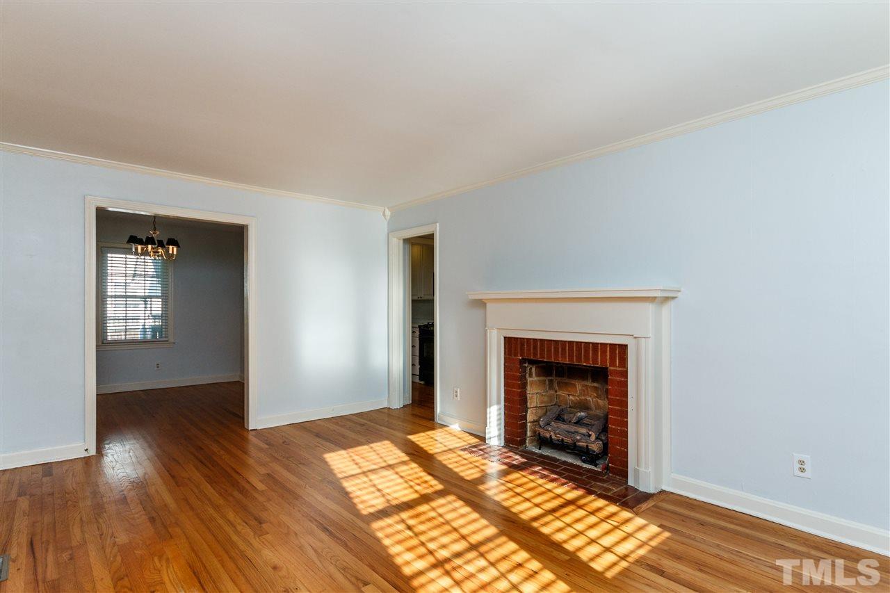 607 Frank Street Raleigh, NC 27604 - Photo 5 of 23 an empty room with wooden floor fireplace and windows