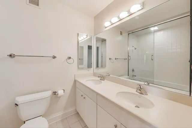a bathroom with a sink and mirror with toilet