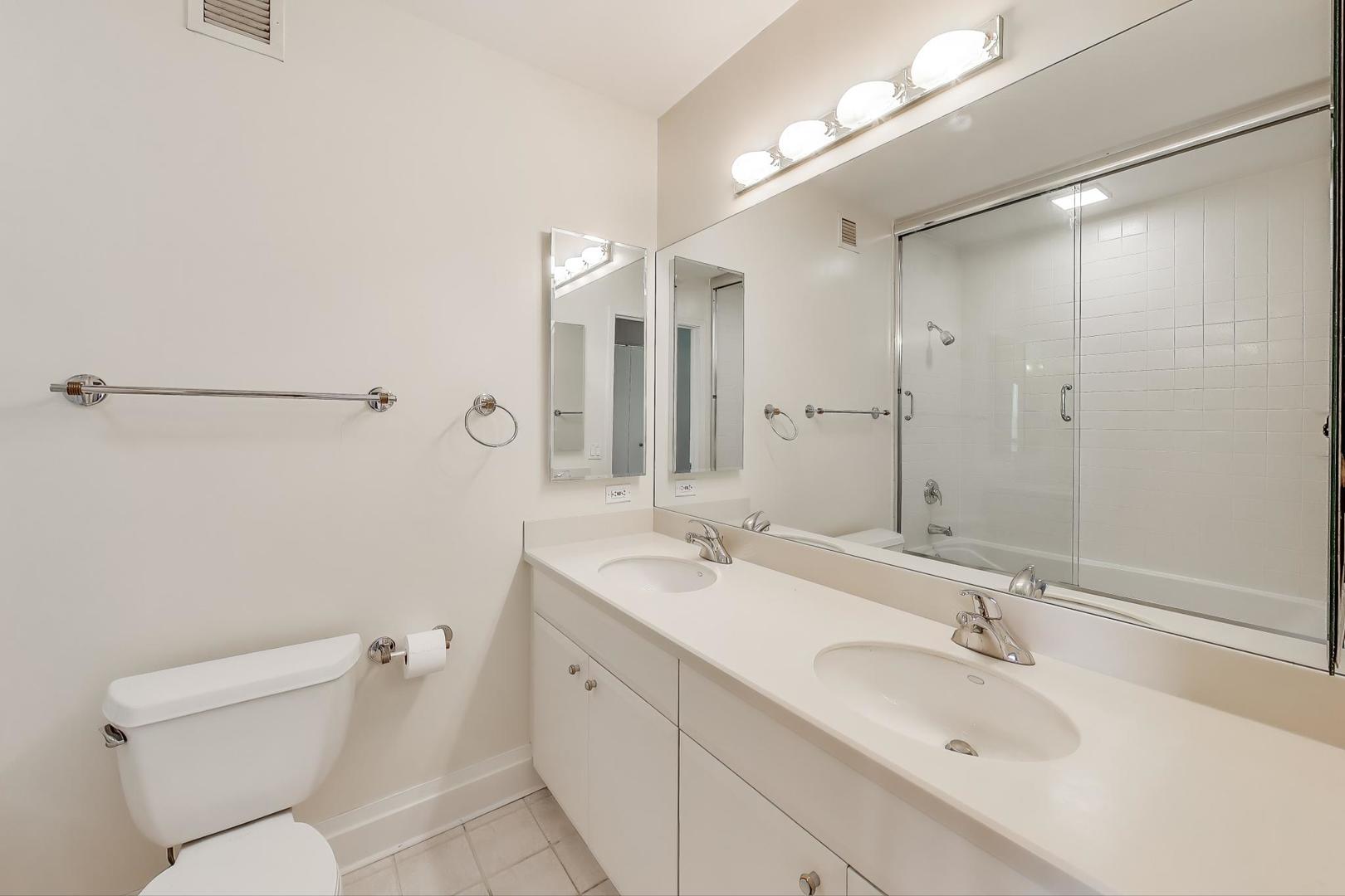 33 West Ontario Street, Unit 30G Chicago, IL 60654 - Photo 11 of 25 a bathroom with a sink and mirror with toilet