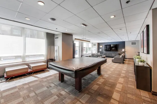 a living room with furniture a flat screen tv and a window