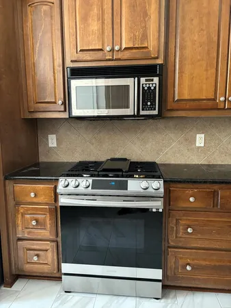 a stove top oven sitting inside of a kitchen