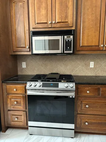a stove top oven sitting inside of a kitchen