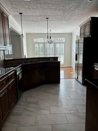 a kitchen with granite countertop a refrigerator and a sink