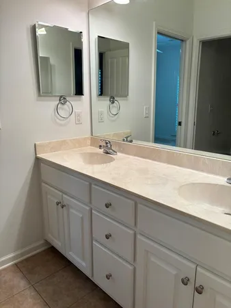 a bathroom with double sink and a mirror