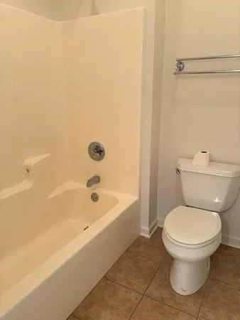 a white toilet sitting next to a bath tub