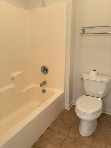 a white toilet sitting next to a bath tub