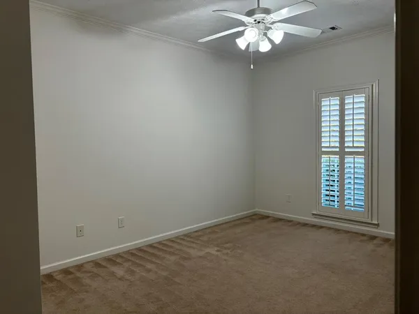 an empty room with a window and a fan