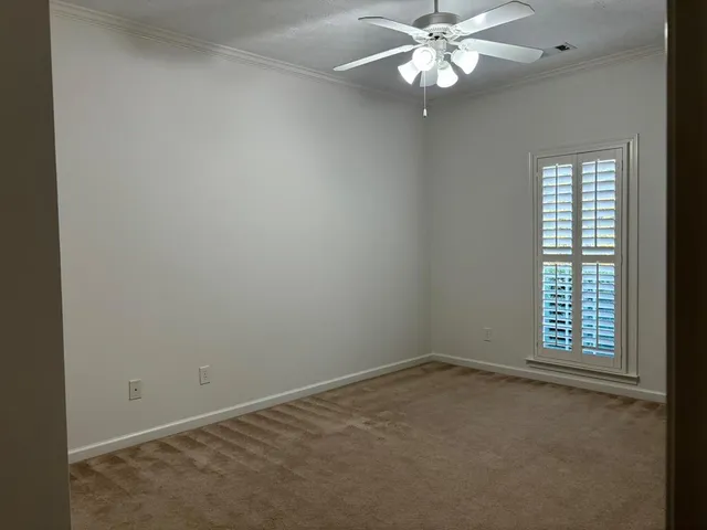an empty room with a window and a fan